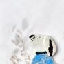Słodki piesek nosi niebieski sweterek, dodający mu nuty przytulności. Ceramika
