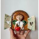 Ceramiczny anioł z jabłuszkiem w okiennicy