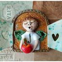 Ceramiczny anioł z jabłuszkiem w okiennicy