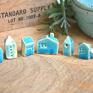 Zestaw 6 miniaturowych domków z ceramiki z detalami takimi jak komin, dachówka, okna i drzwi. Uroczy drobiazg na półce