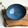Ręcznie formowana misa ceramiczna pokryta jest szkliwami spożywczymi w odcieniach niebieskiego, granatu i matowej czerni. Ceramika
