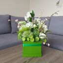 Flowerbox dekoracyjny z bocianami w zielonym boxie - wiosenna kompozycja kwiatowa do domu