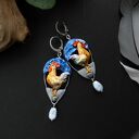 Kolczyki z kogutami w rustykalnym, wiejskim klimacie - folkowe ptaki na niebieskim tle