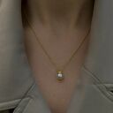 gustowne złoty naszyjnik z perłą w koronie