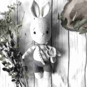 Beżowy króliczek eryczek w granatowych spodenkach maskotki miedzy motkami urodziny, chrzest
