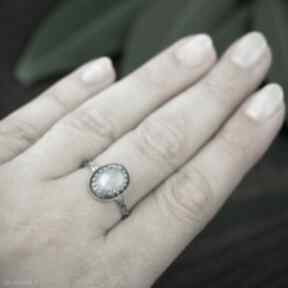 Srebrny pierścionek z kamieniem księzycowym w koronce, błękitnym oczkiem pracownia