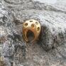 pierścionek wykonany z mosiądzu. Inspiracją do jego stworzenia były serowe dziury. Masywny pierścień