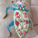 Poszewka z haftem chrząszcza - w objęciach róży