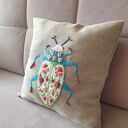 Poszewka z haftem chrząszcza - w objęciach róży