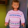 Różowy sweterek z wzorkami, na ramieniu plisa z 3 guziczkami, ułatwiająca zakładanie sweterka. Włóczka