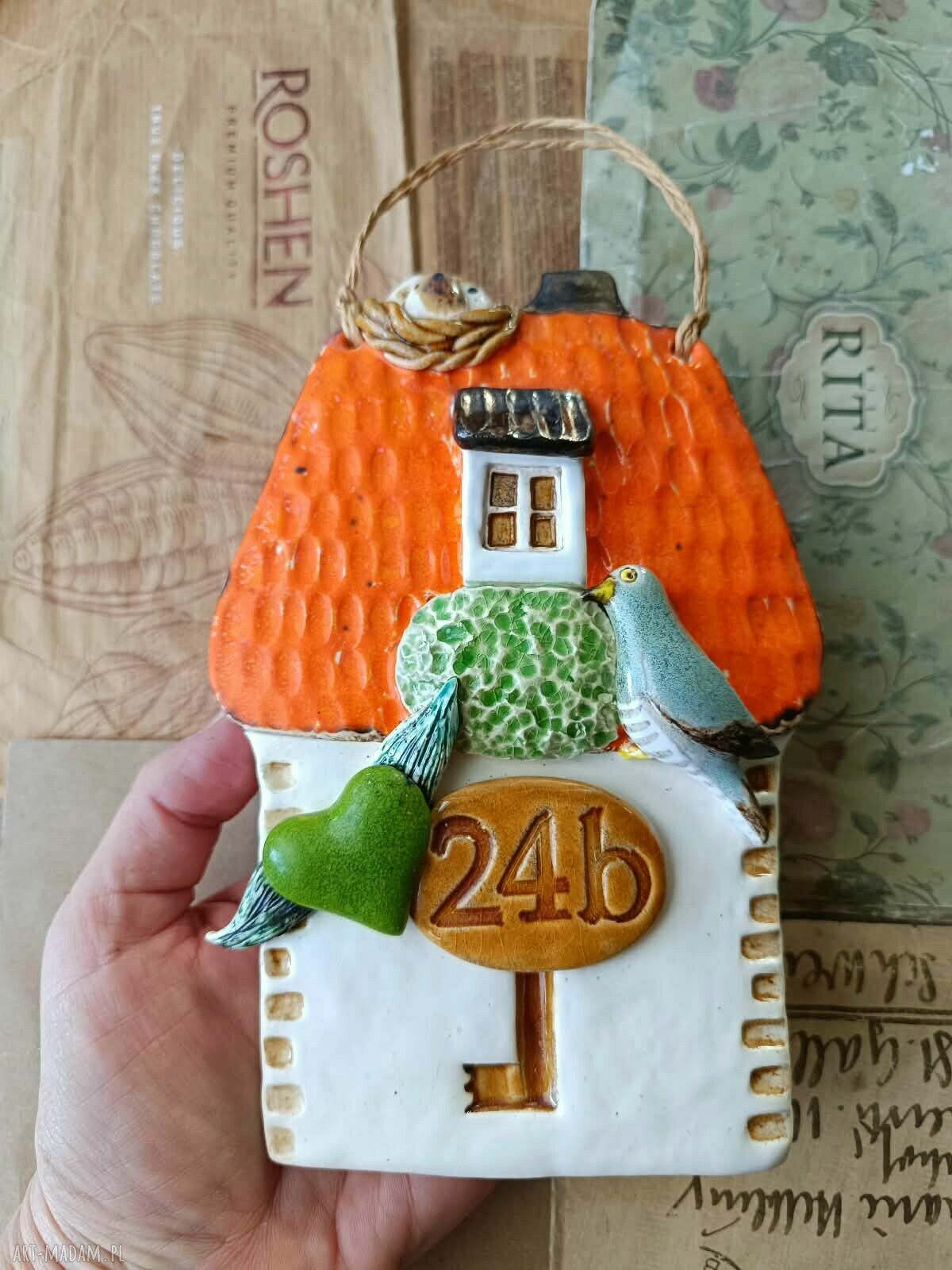 Ceramiczny domek z numerem domu i kukułką