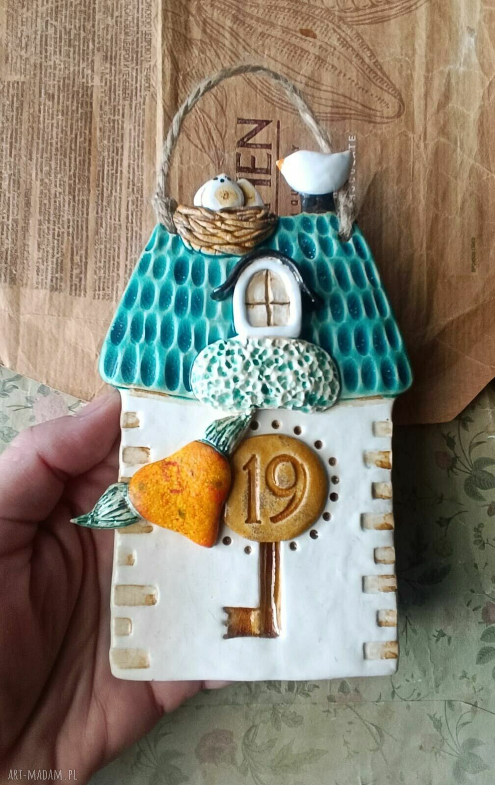 Turkusowy ceramiczny domek z numerem na drzwi