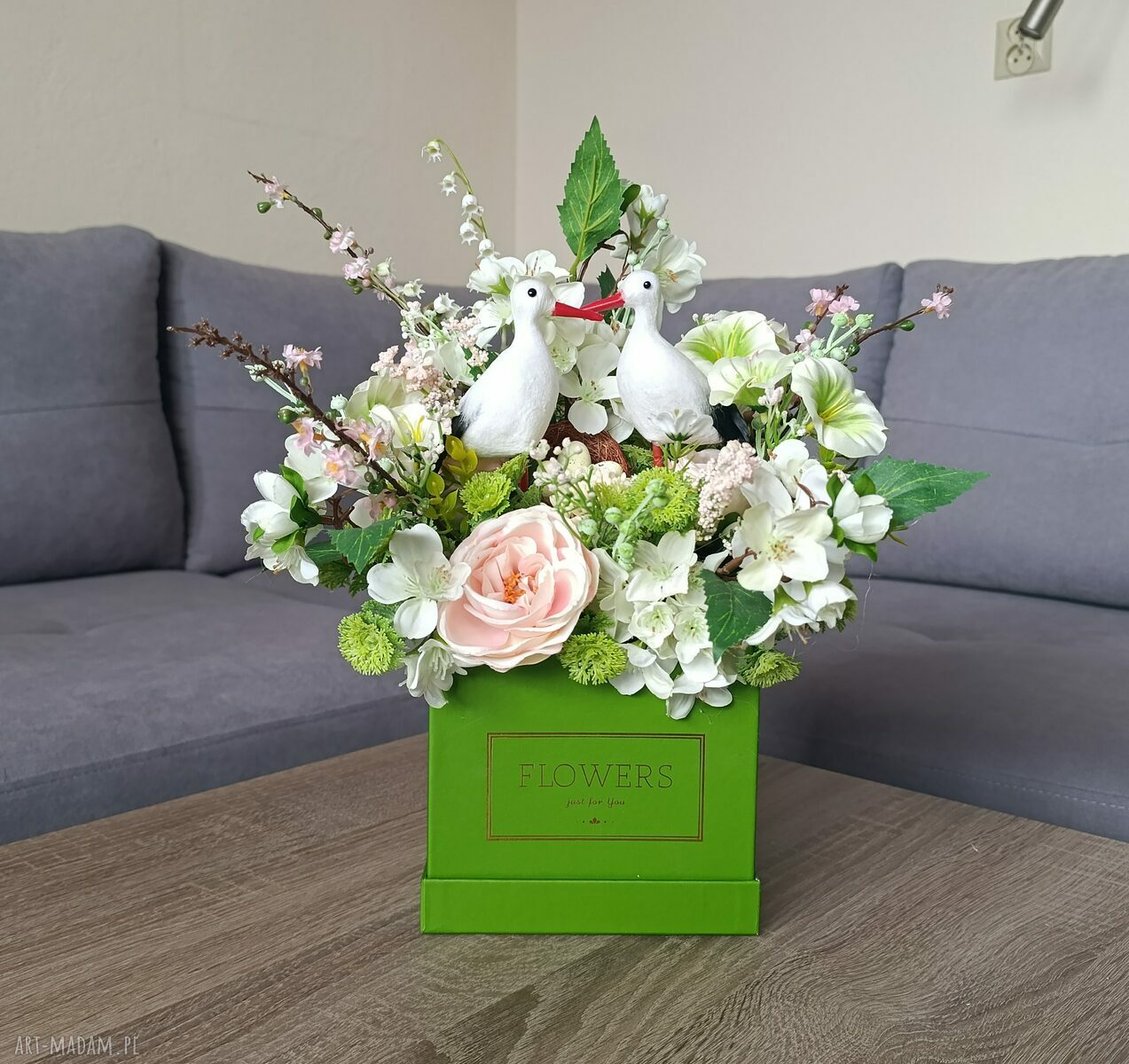 Flowerbox dekoracyjny z bocianami w zielonym boxie - wiosenna kompozycja kwiatowa do domu