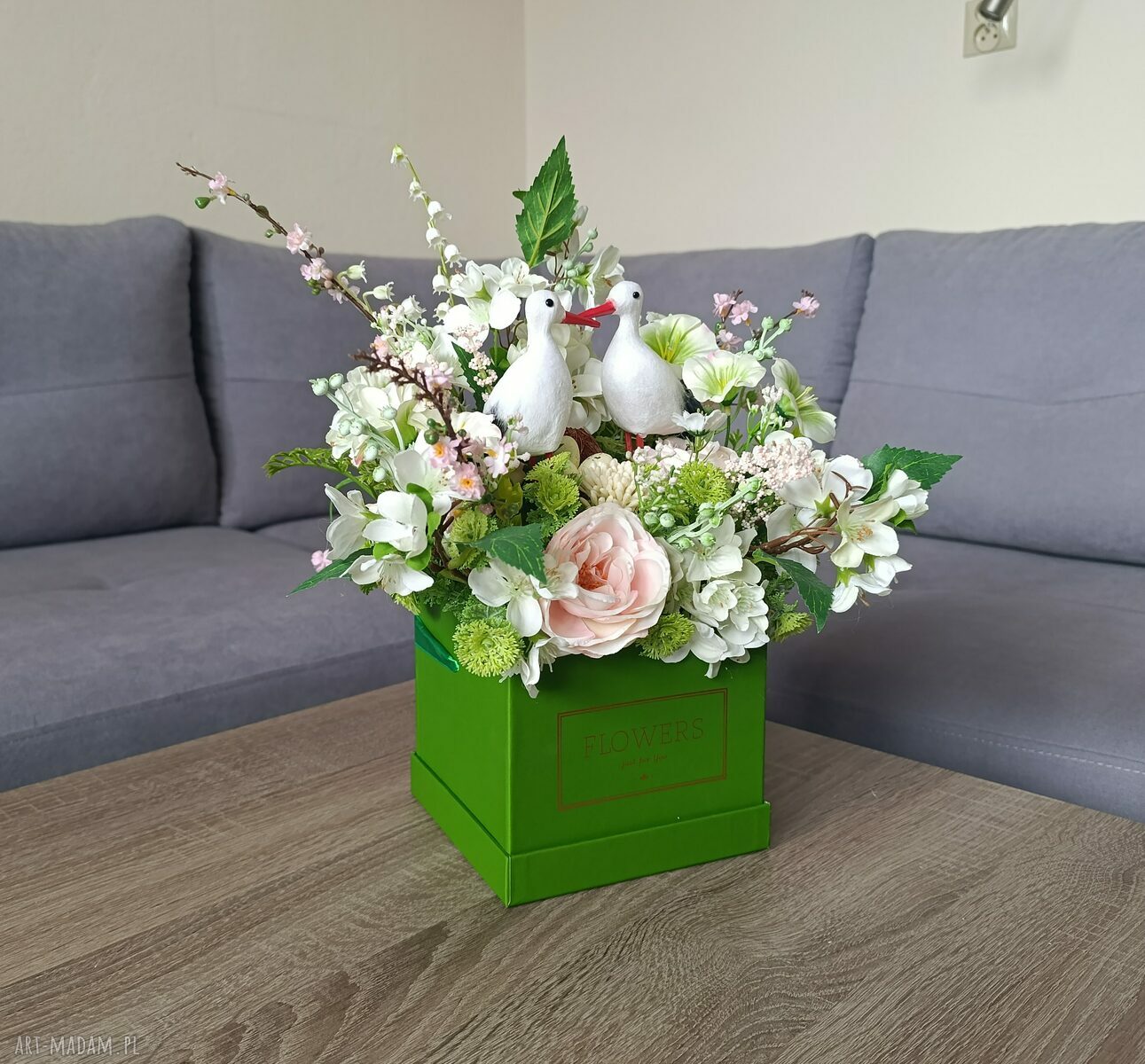 Flowerbox dekoracyjny z bocianami w zielonym boxie - wiosenna kompozycja kwiatowa do domu