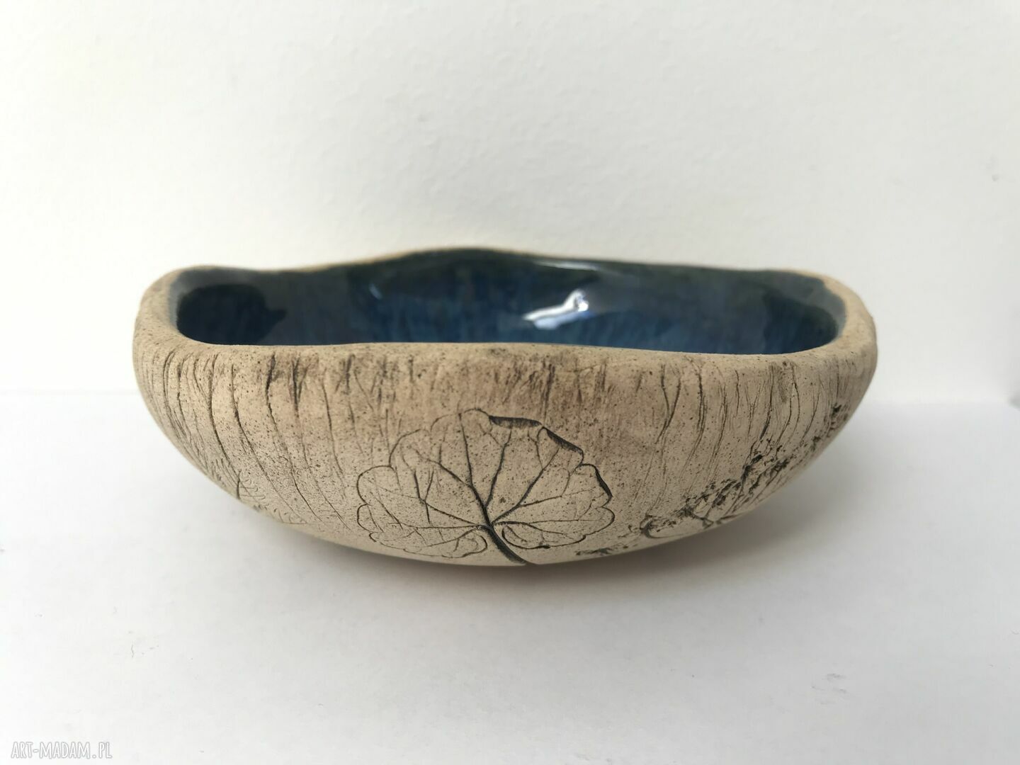 Organiczna miseczka ceramiczna z odbiciem polnych roślin