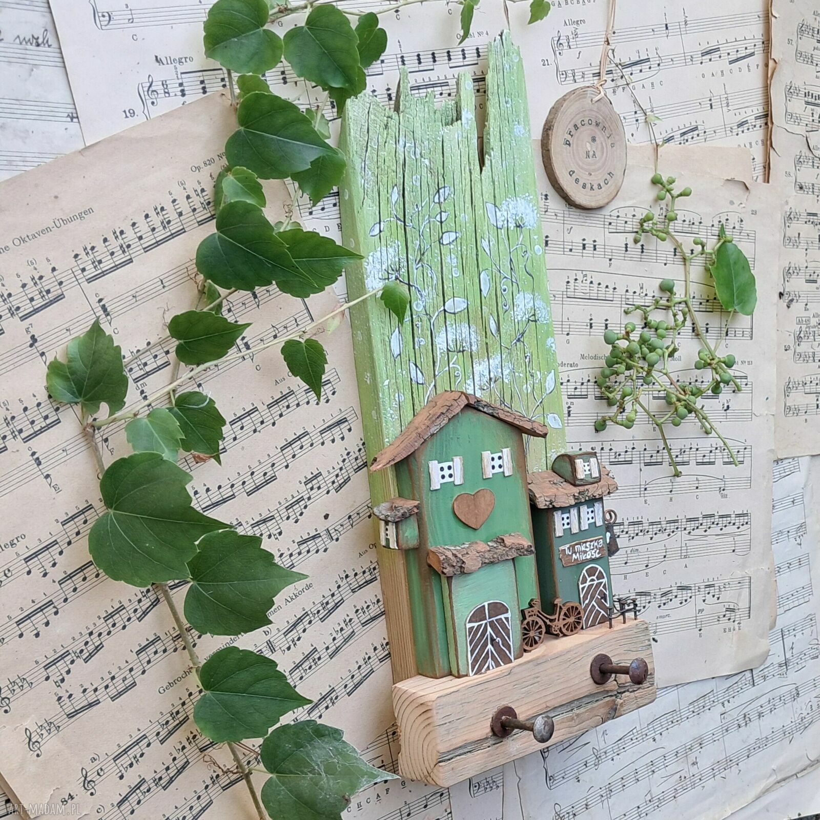 Rustykalny drewniany wieszak z domkiem wśród zieleni