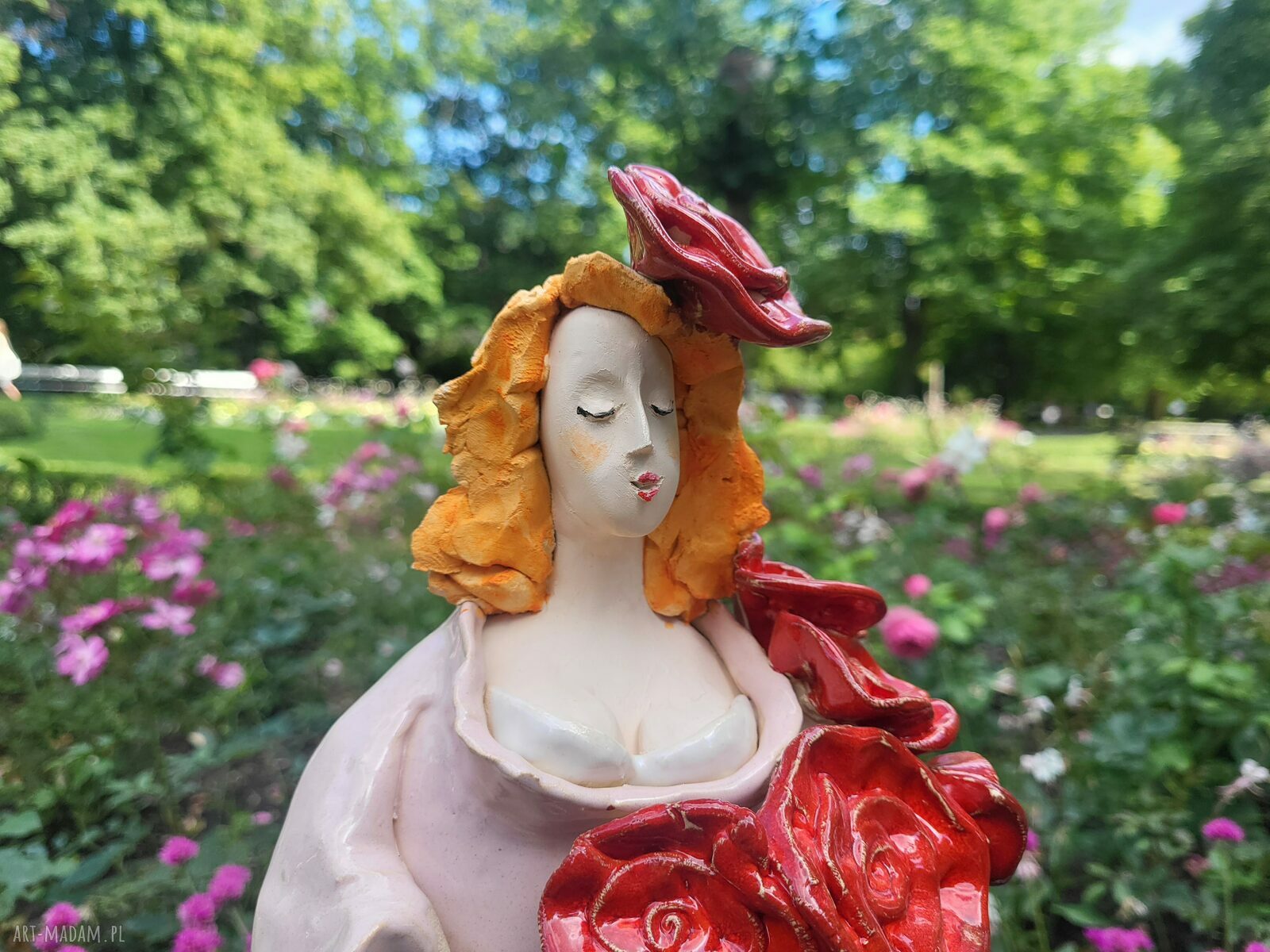 Rzeźba ceramiczna kobiety z czerwonymi kwiatami